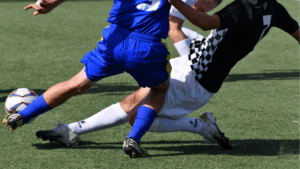 サッカーをする男性学生