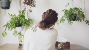 肩を抑える女性