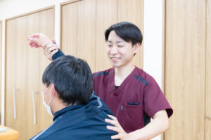 肩関節のリハビリをする男性理学療法士